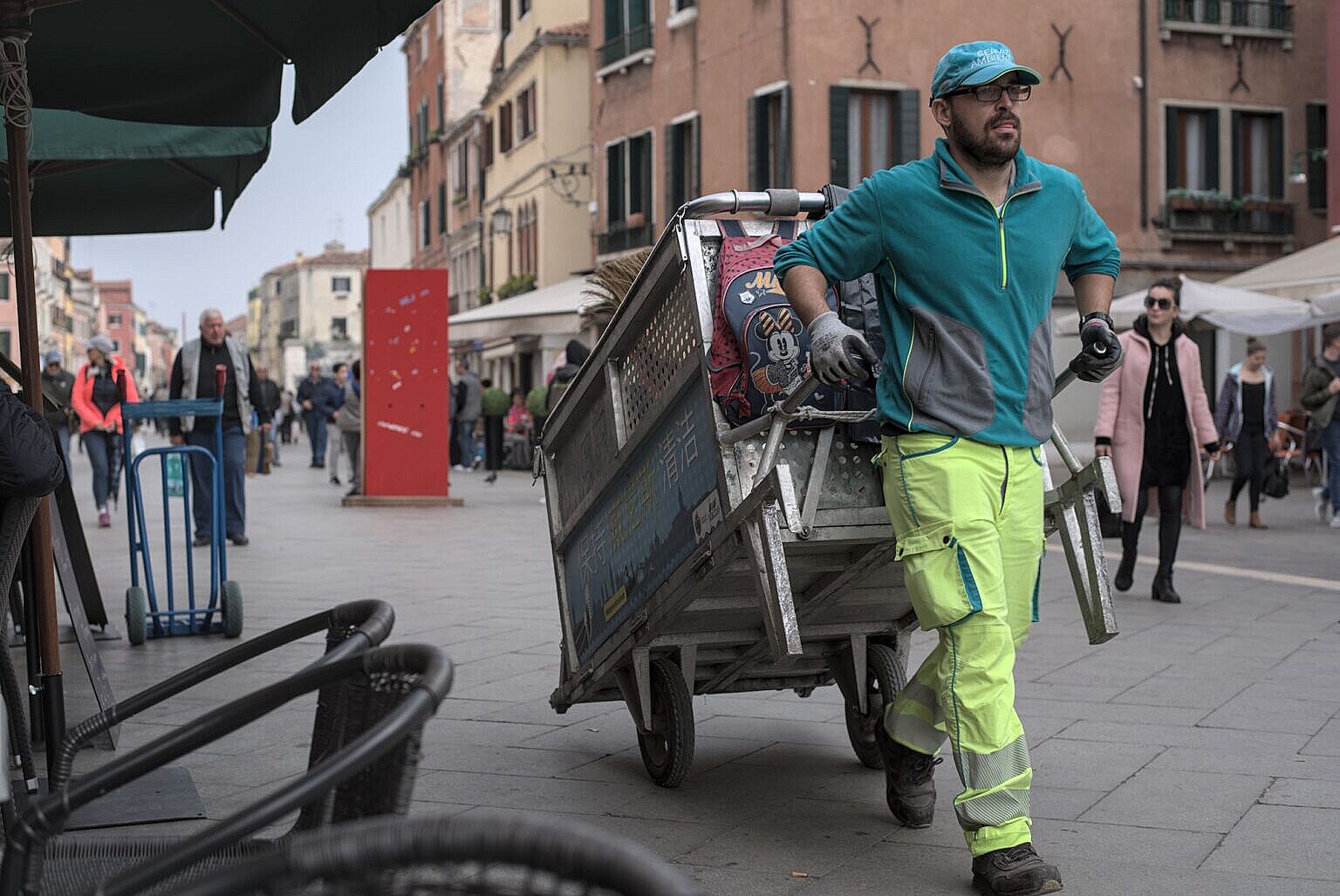 Photo of a garbage collector in the Via Garibaldi with his hand drawn cart.