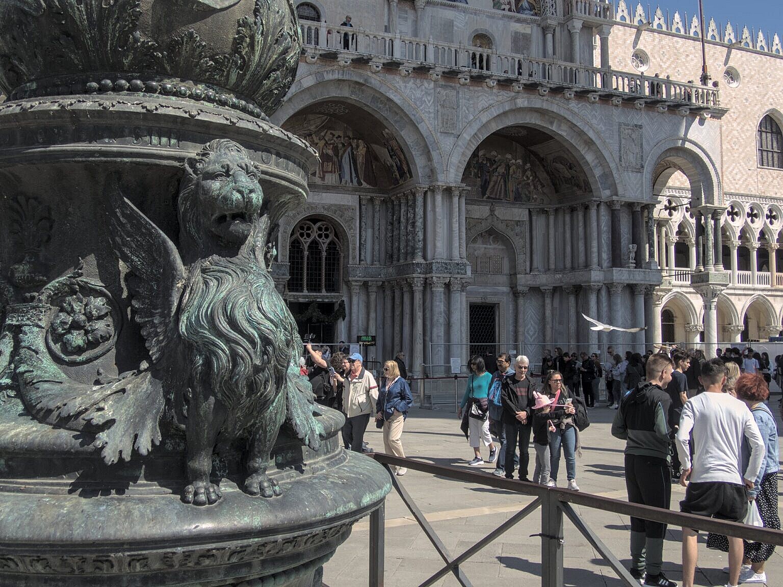 Winged lion of St Mark in moeca on a flagpole base in Piazza San Marco